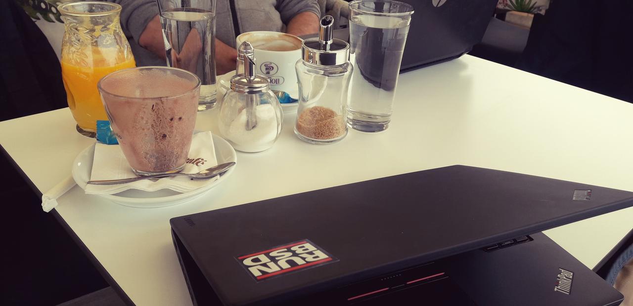 Computers and beverages on a table in a cafe